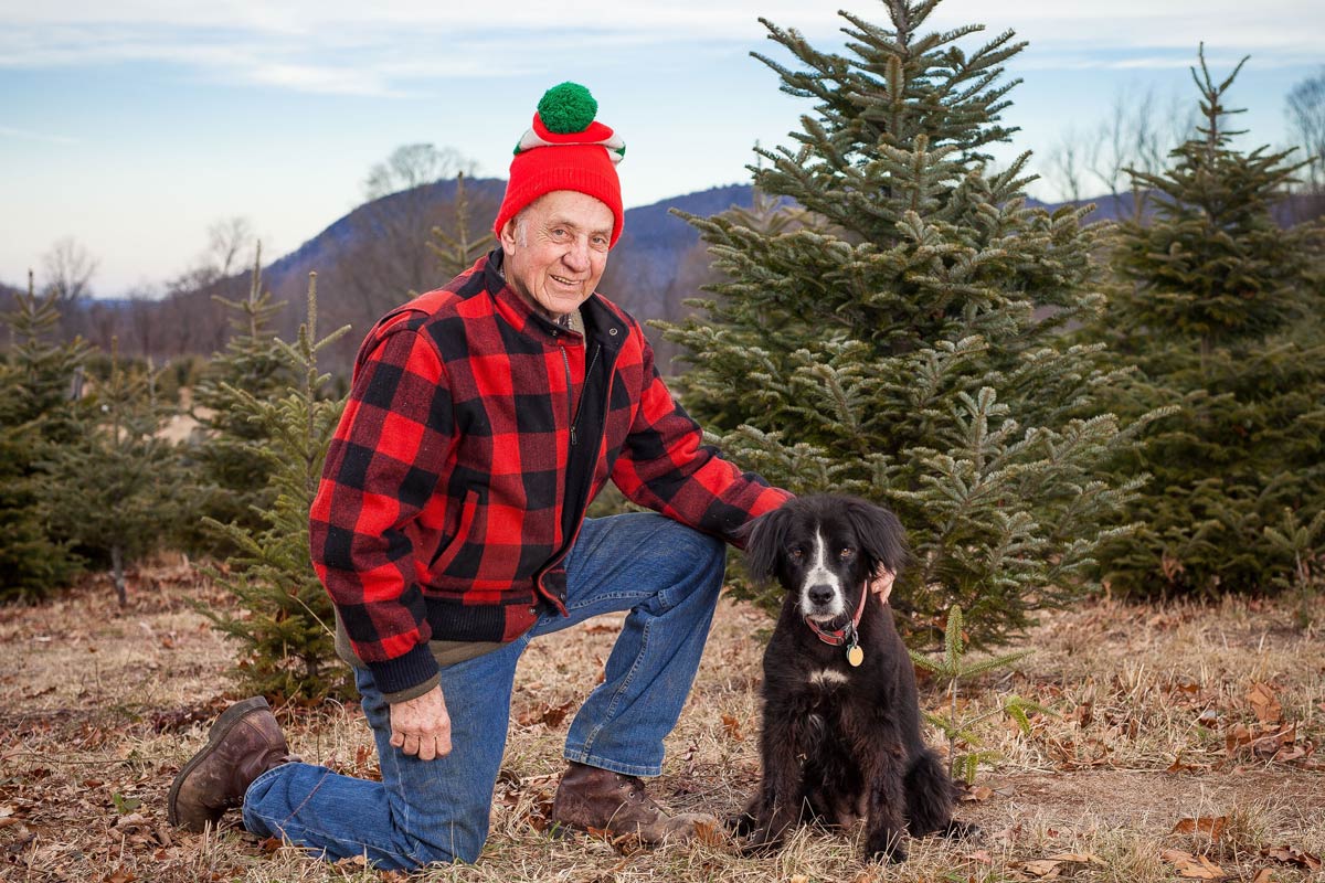 owner kneeling down with dog in the field