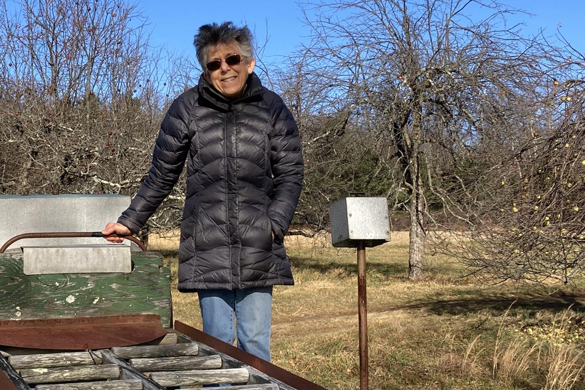 Joan Barney standing on orchard machinery