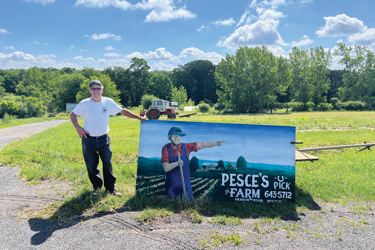 Larry standing in front o the Pesce sign
