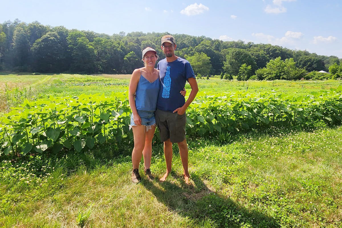 Farmers standing in front a row of crops